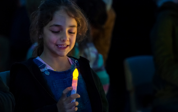 Fundraise your way for cancer survival like this child holding a fundraising candle.