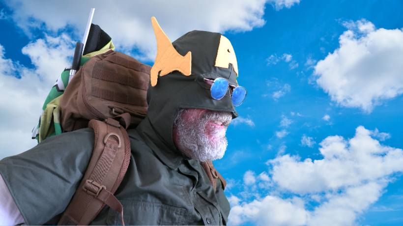 Captain Australia wears his hero uniform and his hero backpack with a blue, cloud-spattered sky behind him.