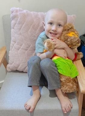 Child with bear provided by cancer research charity