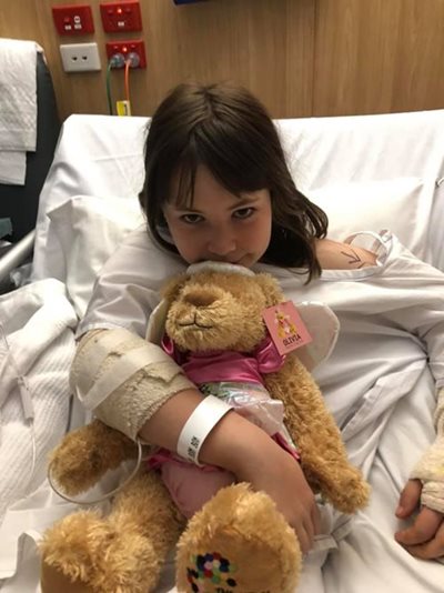 Young girl in hospital holding a princess bear