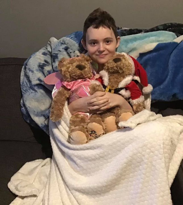 Girl undergoing hospital treatment hugging santa bear and fairy bear