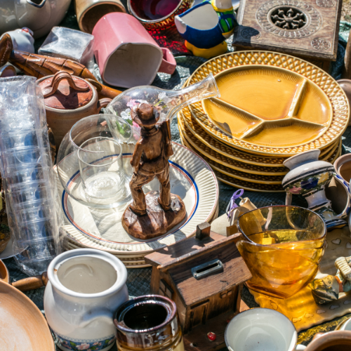 A selection of bric-a-brac, ornaments and other household items are arranged on a table.