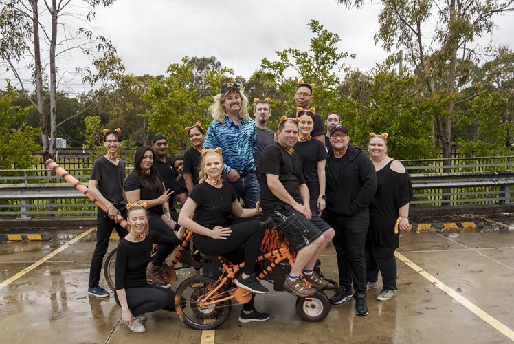 Bromic racing team gathered around their kart, dressed up in Tiger King themed costumes.