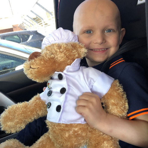 Ollie in his car with Chef Bear