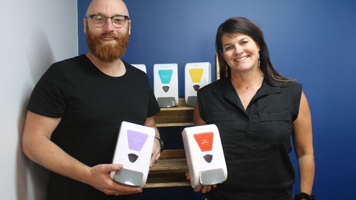 A man and a woman present a selection of Taren's cleaning and sanitation products.