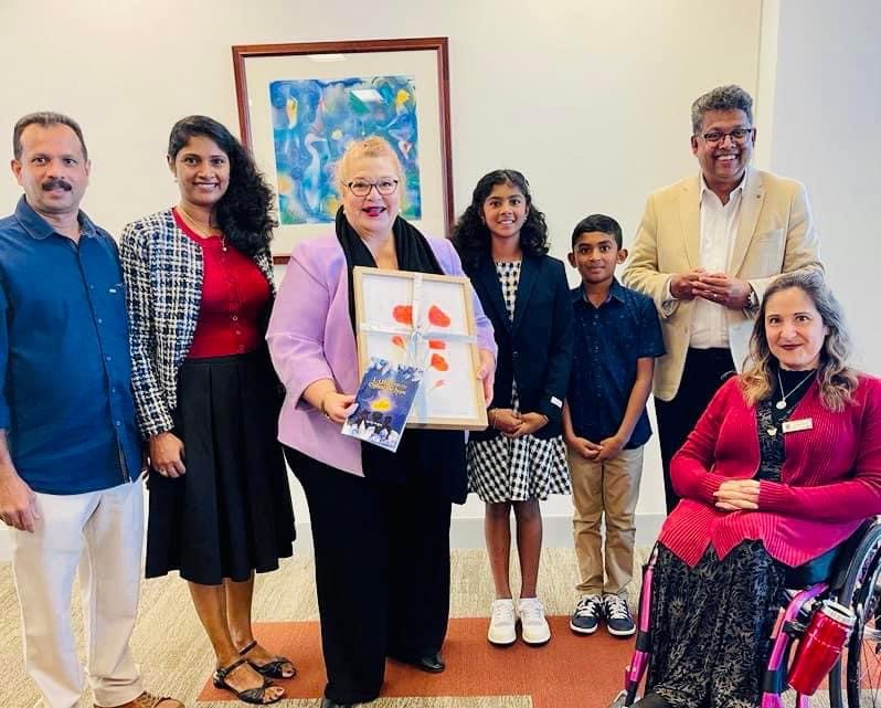 12 year old Shivani stands proudly with her family, presenting her book to TKCP